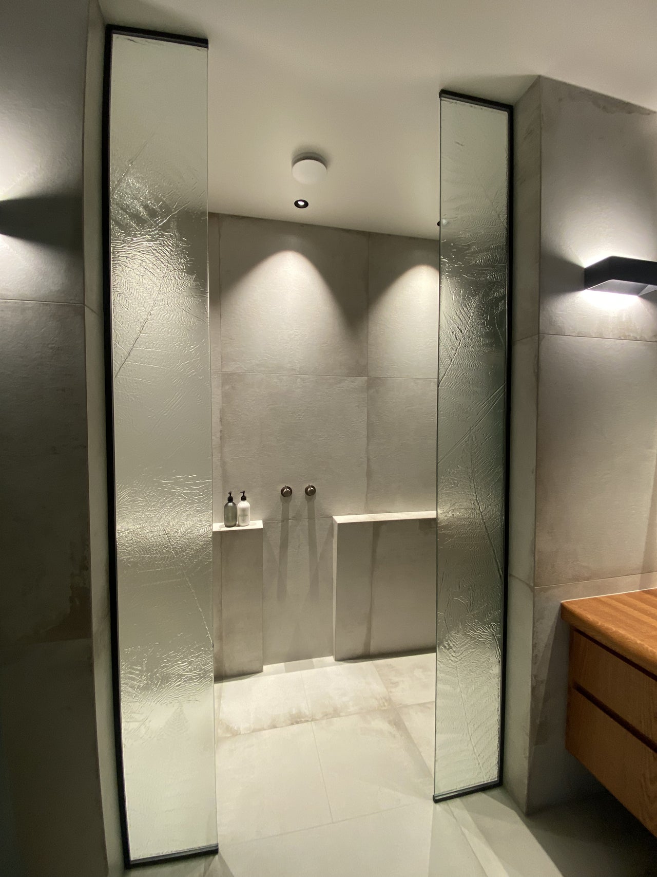 Slumped glass on black hardware for a shower entry